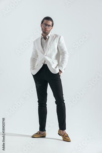 fashion young man with white jacket suit holding hands in pockets photo