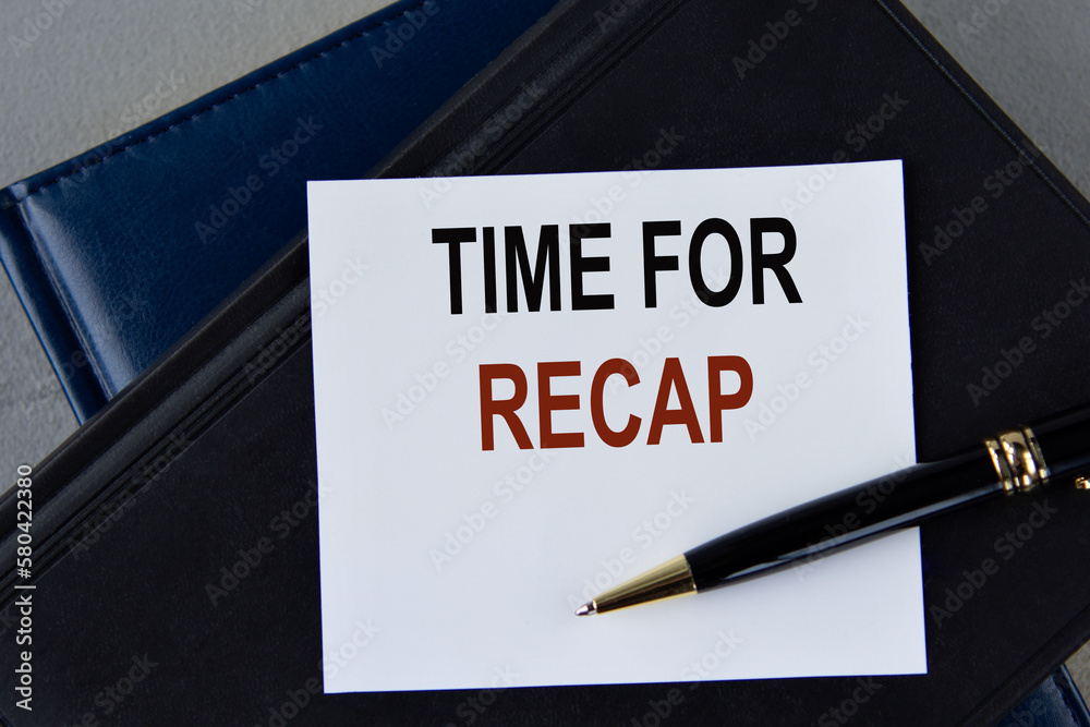 TIME FOR RECAP - words on white sheet on a black leather book with pen