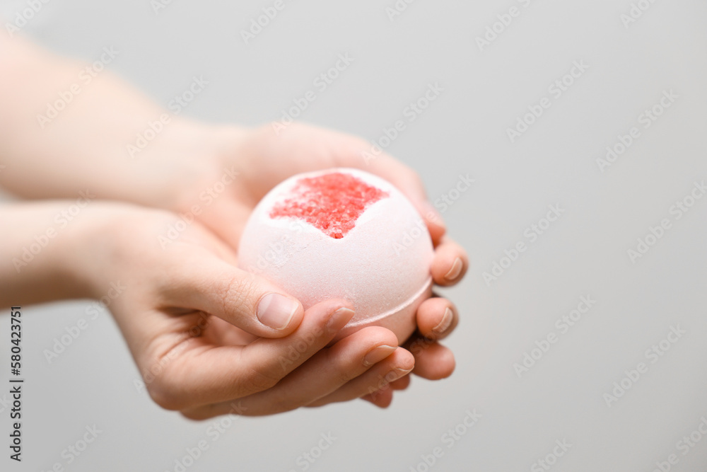 Woman with bath bomb on light background Woman with bath bomb on light background