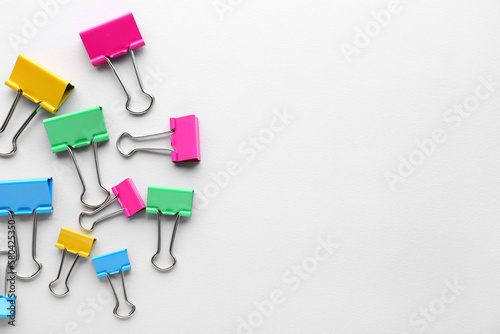Colorful binder clips on grey background
