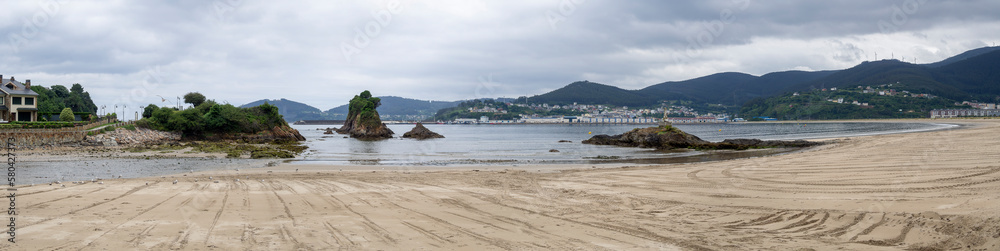 Vista panorámica de la Playa de Covas, en Lugo, Galicia, con la marea baja, arena dorada y rocas en el mar, en verano de 2021 España.