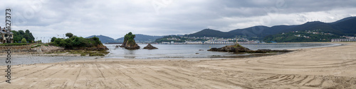 Vista panorámica de la Playa de Covas, en Lugo, Galicia, con la marea baja, arena dorada y rocas en el mar, en verano de 2021 España. photo