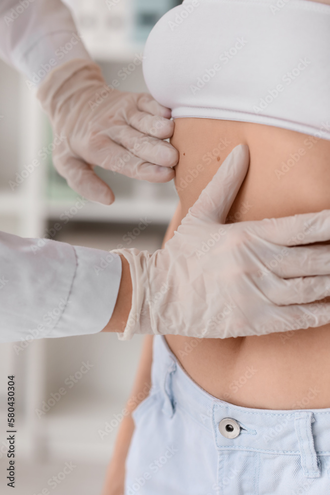 Obraz premium Doctor examining patient's skin for moles and skin cancer, medical checkup and dermatology consultation, this dermatology consultation emphasizes early detection and prevention of skin diseases