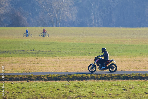 Unidentified man with helmet riding a motorcycle on the countryside