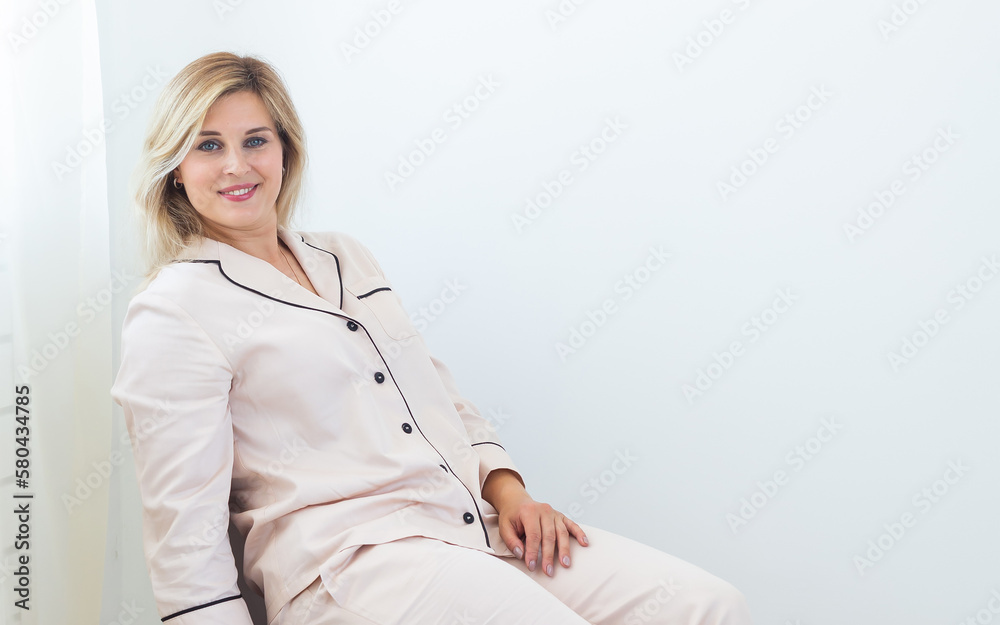Carefree young woman in cozy pajamas resting on chair at home - wellbeing and comfort morning concept Carefree young woman in cozy pajamas resting on chair at home - wellbeing and comfort morning concept