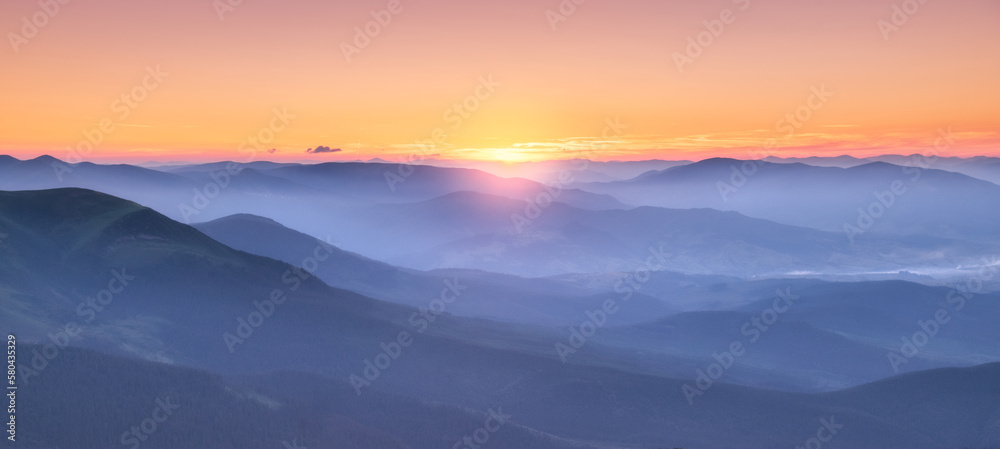 Amazing silhouettes of a mountains at colorful sunset in summer in Ukraine. Landscape with mountain ridges in fog, golden sunlight in the evening. Nature. Hills in sunlight. Scenery