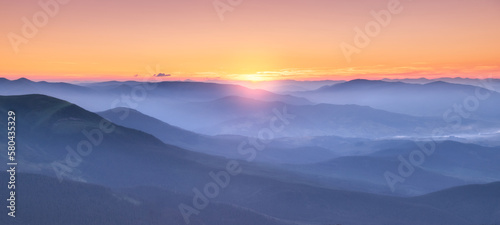 Amazing silhouettes of a mountains at colorful sunset in summer in Ukraine. Landscape with mountain ridges in fog  golden sunlight in the evening. Nature. Hills in sunlight. Scenery