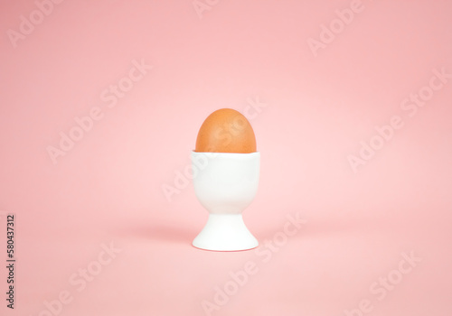 Eegg in egg cup on a pink background. Easter concept. photo
