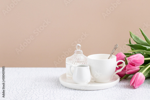 Foto Ceramic tea-set with cup and milk jug on the table