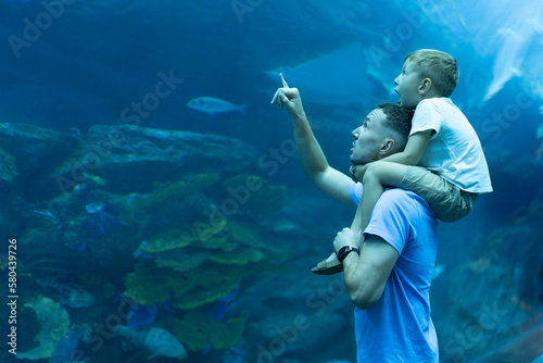 Canvas Print Dad and son spend time together in the Aquarium