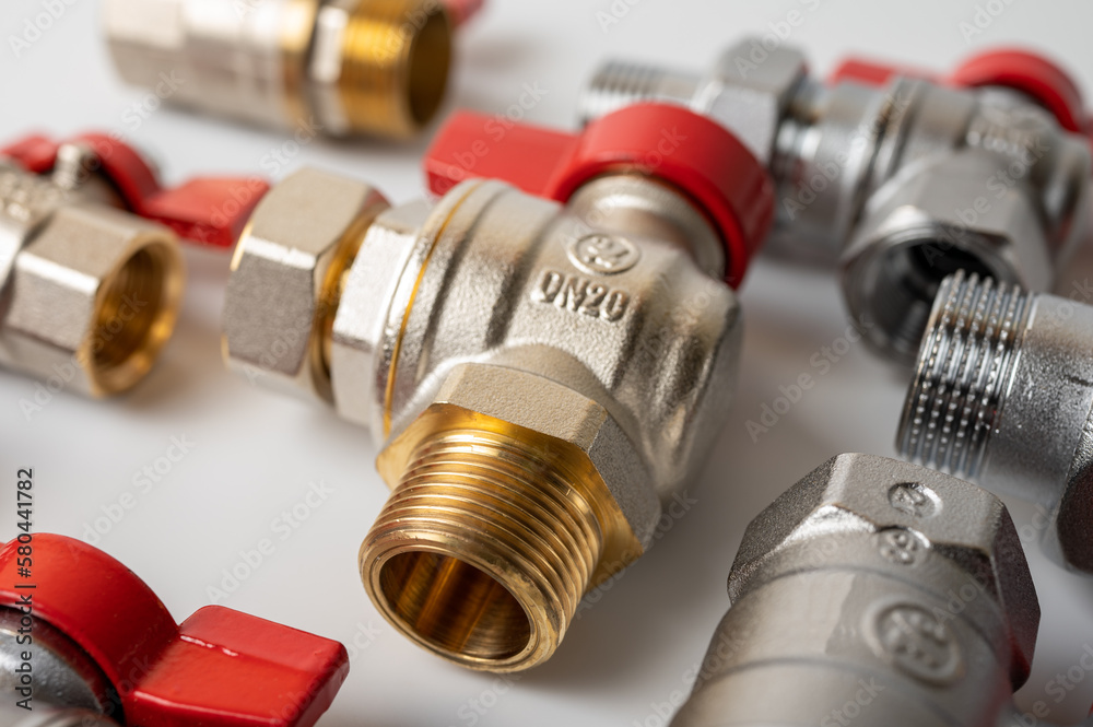 brass, metal water faucets with red valve, different, isolated on light background close-up, plumbing connection brass, metal water faucets with red valve, different, isolated on light background close-up, plumbing connection