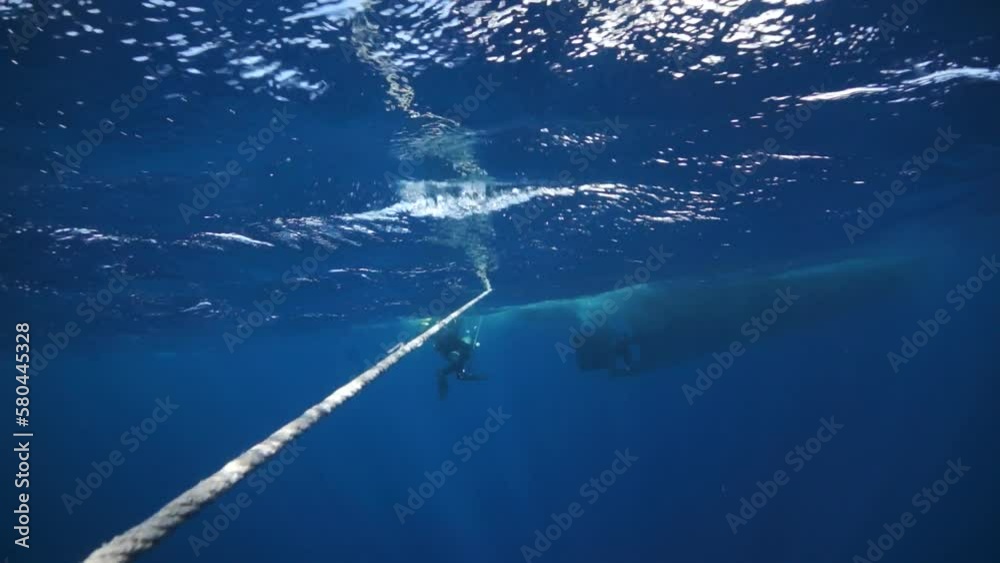 Rope underwater and bubbles and diver in slow motion. Diver are ...