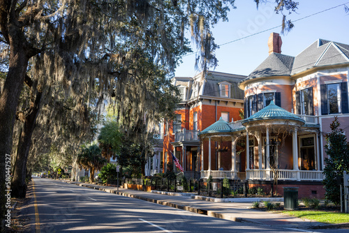 Spanish moss hangs over historic Savannah, Georgia, homes next to Forsyth park in the early morning  photo