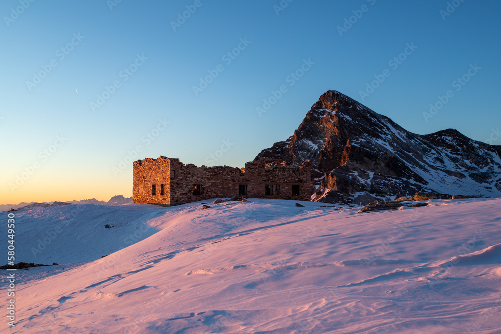 Fototapeta premium il chersogno e una vecchia casermetta diroccata innevati in una fredda alba invernale