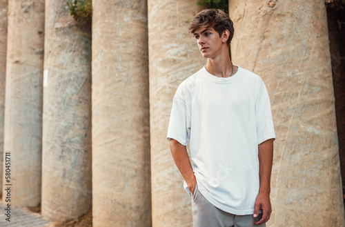 Young handsome hipster guy wearing white blank t-shirt . Mock-up for print. T-shirt template.