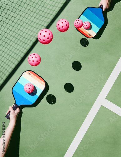 Hands-holding-pickleball-paddles-with-pink-balls