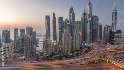 Skyscrapers of Dubai Marina near intersection on Sheikh Zayed Road with highest residential buildings day to night timelapse