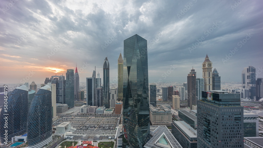 Obraz premium Panorama of futuristic skyscrapers with sunset in financial district business center in Dubai on Sheikh Zayed road timelapse