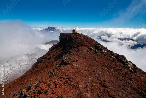 fotografia de montaña con Vista del volcán Tolhuaca entre las Nubes desde la cumbre del volcán Lonquimay, region de la Araucanía, Chile photo