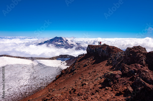 fotografia panoramica Vista del volcán Tolhuaca y montañistas entre las Nubes desde la cumbre del volcán Lonquimay, region de la Araucanía, Chile photo