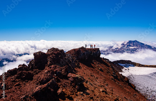 Vista del volcán Tolhuaca y montañistas entre las Nubes desde la cumbre del volcán Lonquimay, region de la Araucanía, Chile photo