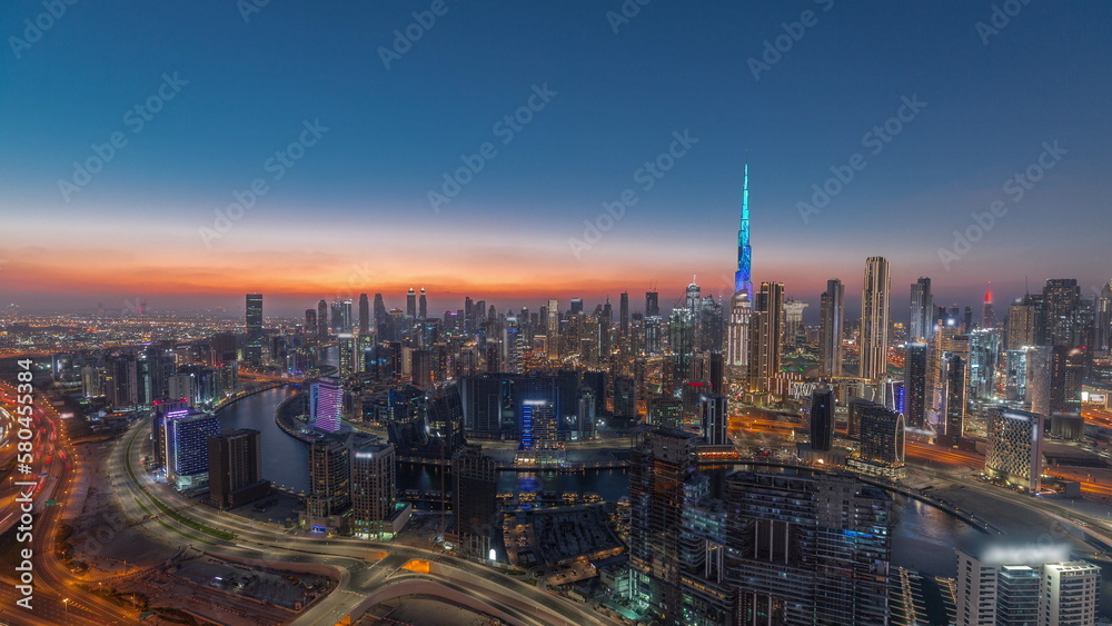 Skyline with modern architecture of Dubai business bay towers day to night timelapse. Aerial view