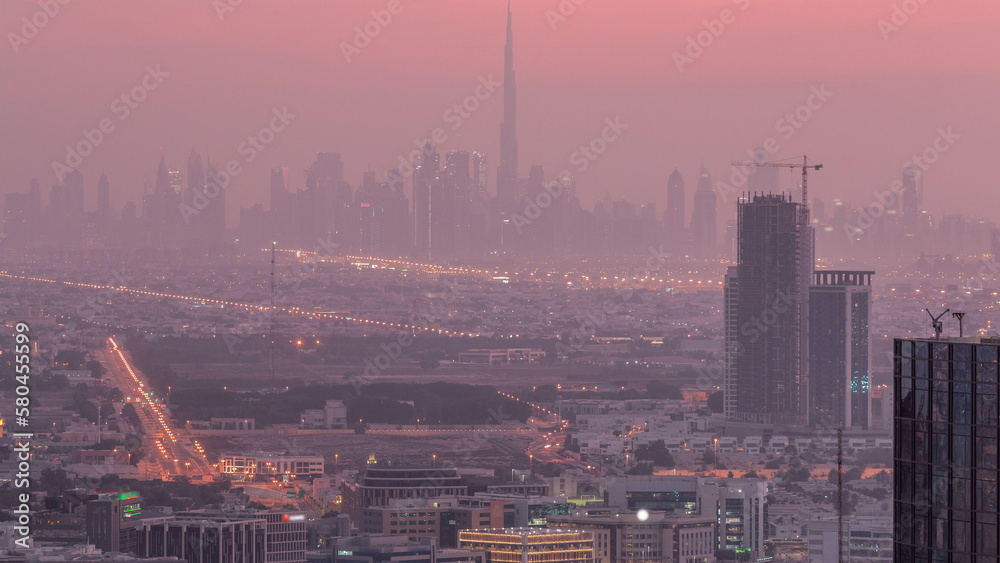 Dubai Downtown skyline row of skyscrapers with tallset tower aerial night to day timelapse. UAE