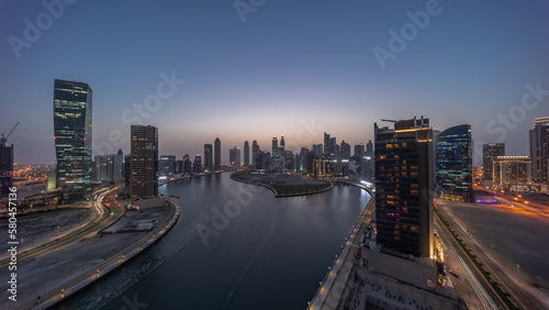 Cityscape of skyscrapers in Dubai Business Bay with water canal aerial day to night timelapse