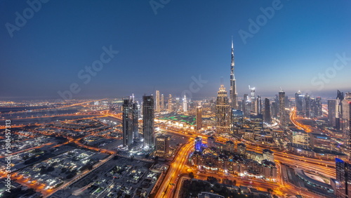 Aerial view of tallest towers in Dubai Downtown skyline and highway day to night timelapse.