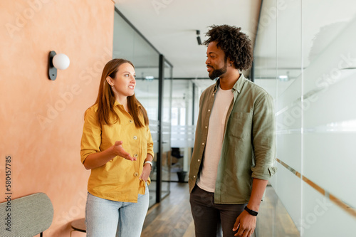 Konstfotografi Young enthusiastic female colleague explains new strategy to male employee and gesturing