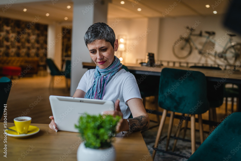 Fototapeta premium One woman mature adult senior female use digital tablet at cafe