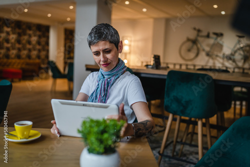 One woman mature adult senior female use digital tablet at cafe