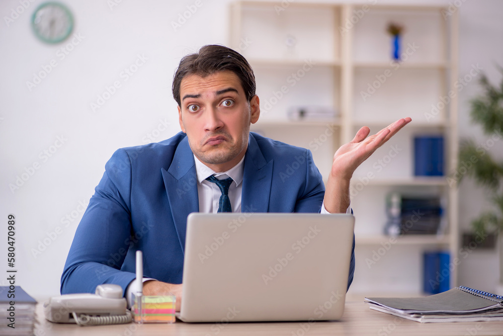 Young male employee working in the office Young male employee working in the office
