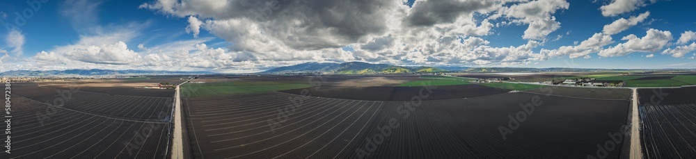 Toro Park and agricultural fields with rain clouds in Salinas, California. Aerial panorama.