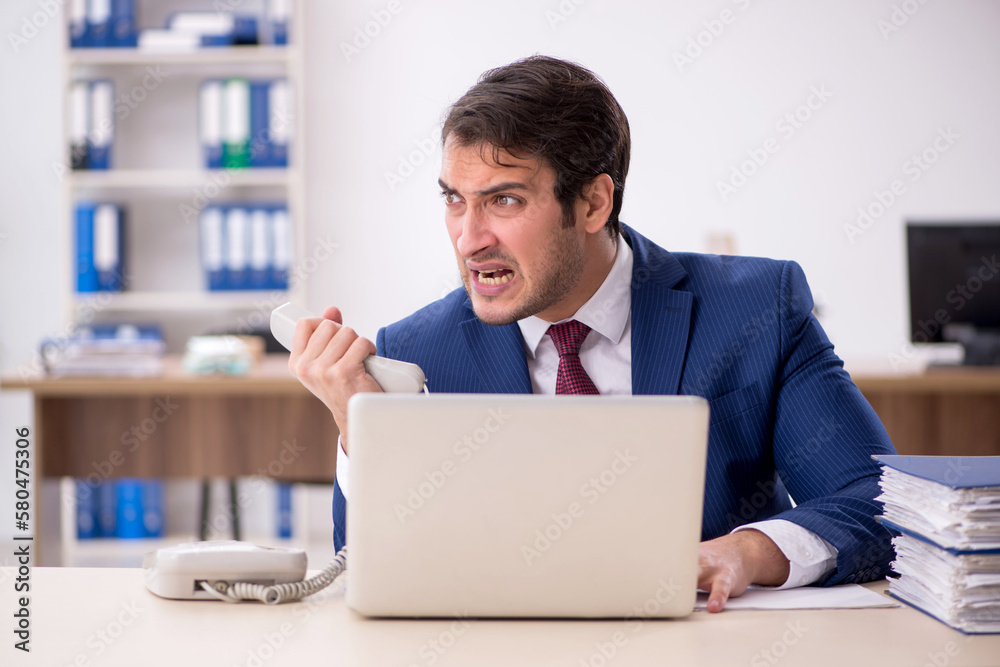 Young male employee working in the office Young male employee working in the office