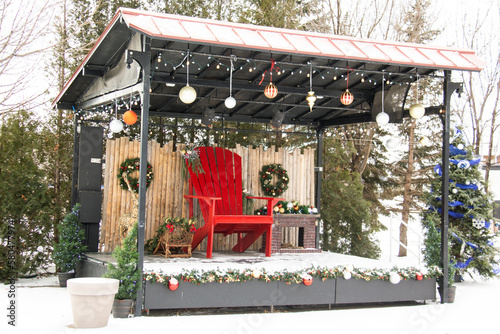 Outdoor christmas stage with a big red chair after a snowstorm