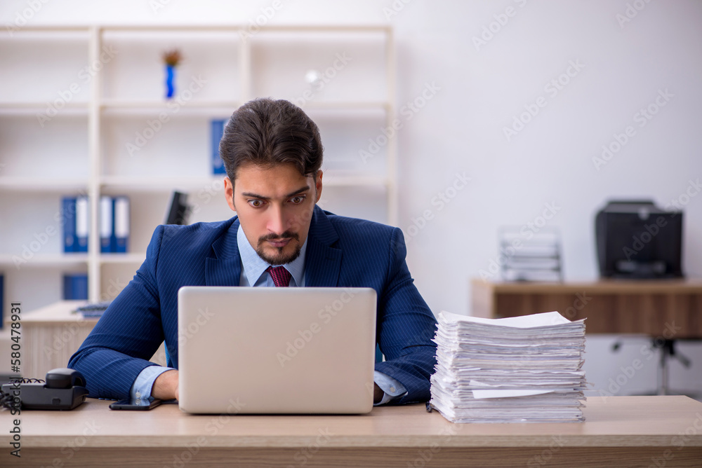 Young businessman employee and too much work in the office Young businessman employee and too much work in the office