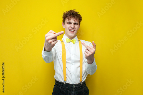 angry guy in festive outfit shows the middle finger, nerd student in shirt with bow tie and suspenders shows fuck