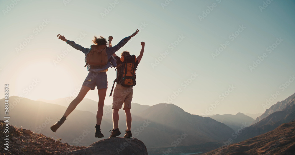 Travel concept with happy couple at mountain top with raised arms and islands at background. Place for text.  - obrazy, fototapety, plakaty 