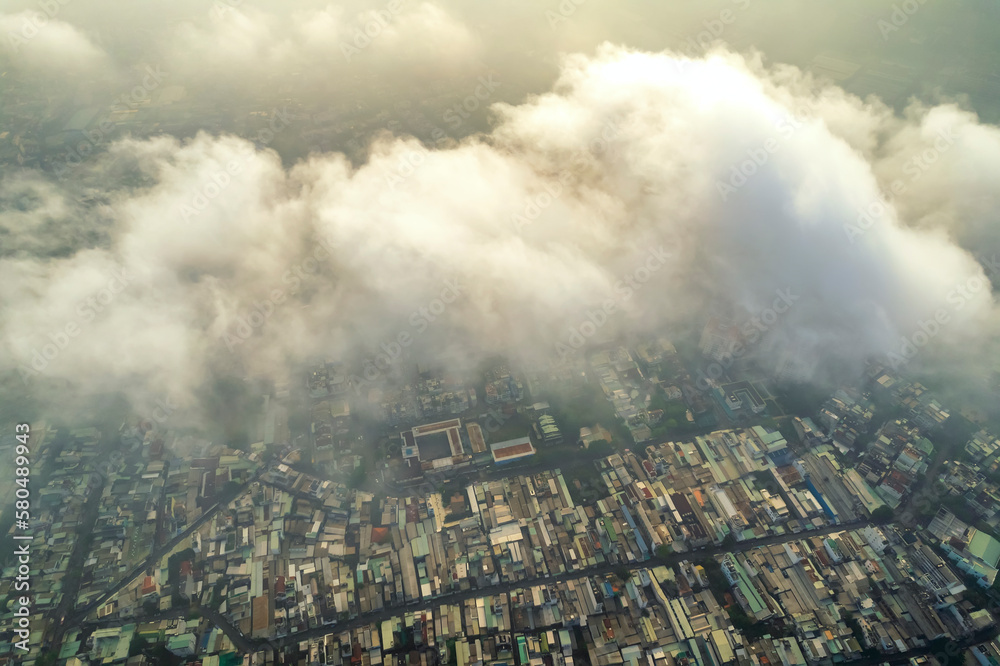 Aerial view of Saigon cityscape at morning with misty sky in Southern Vietnam. Urban development texture, transport infrastructure and green parks
