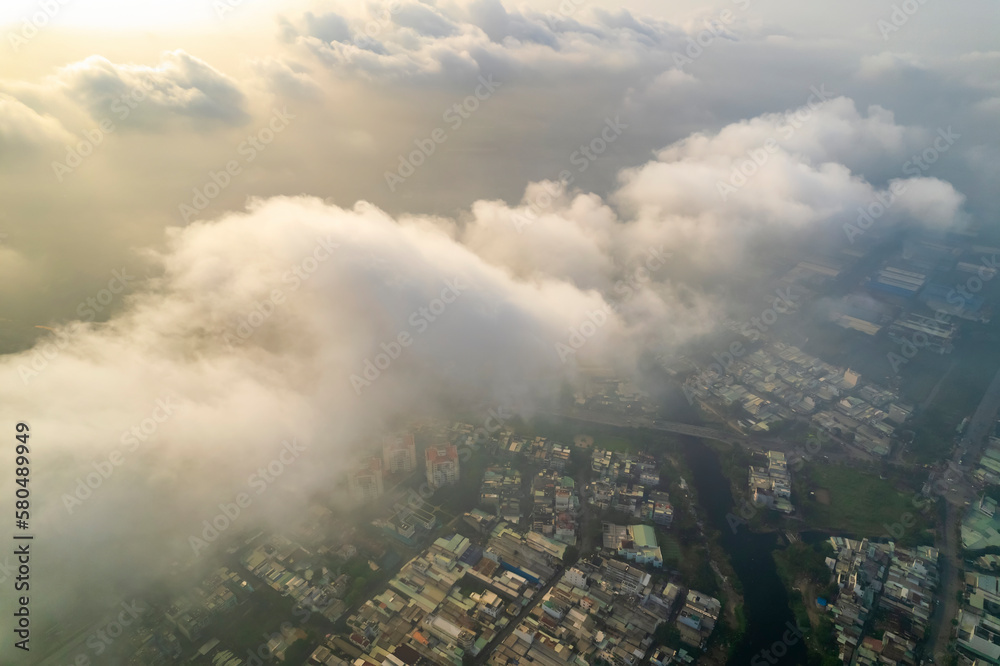 Aerial view of Saigon cityscape at morning with misty sky in Southern Vietnam. Urban development texture, transport infrastructure and green parks