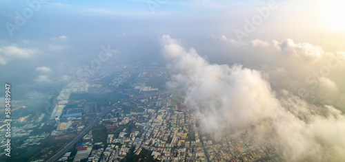 Aerial view of Saigon cityscape at morning with misty sky in Southern Vietnam. Urban development texture, transport infrastructure and green parks