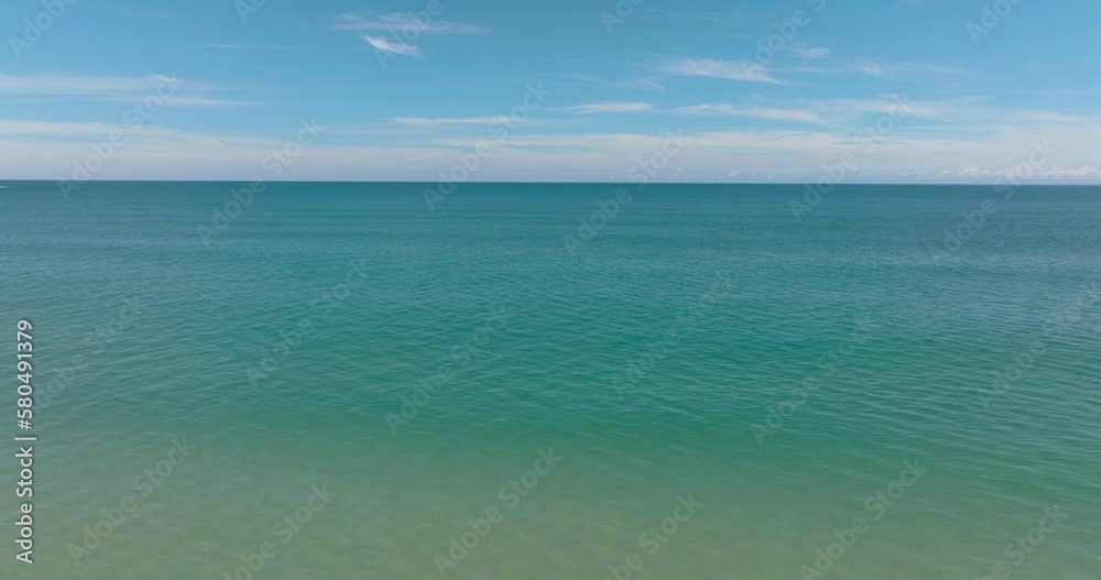 Top view of open blue sea with waves against the sky and clouds. Seascape in the tropics. Borneo, Malaysia. Top view of open blue sea with waves against the sky and clouds. Seascape in the tropics. Borneo, Malaysia.