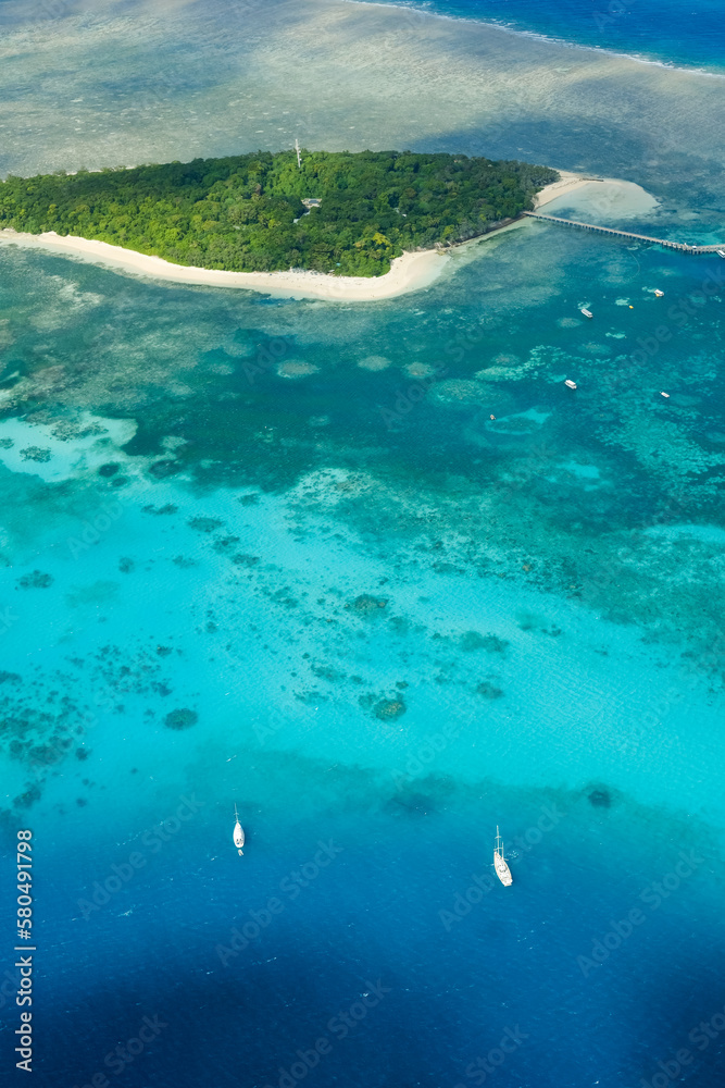 An aerial view of the coral reefs and clear turquoise waters surrounding Green Island, a small tropical isle in the outer Great Barrier Reef — Coral Sea, Cairns; Far North Queensland, Australia	
