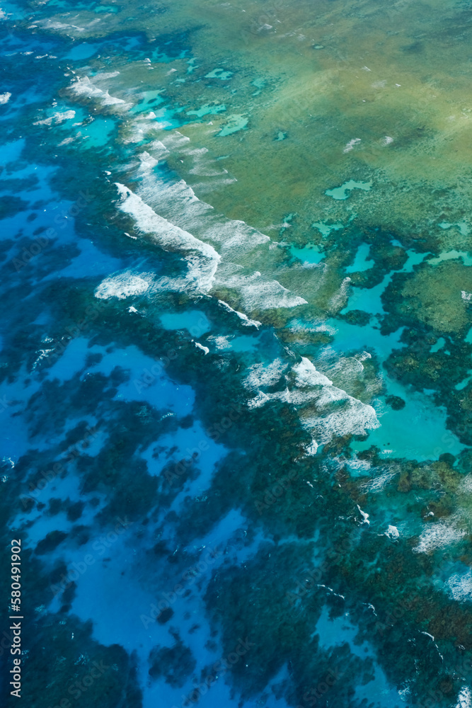 An aerial view of the coral reefs, white sand bars, tropical isles and clear turquoise waters of the Great Barrier Reef — Coral Sea, Cairns; Far North Queensland, Australia	