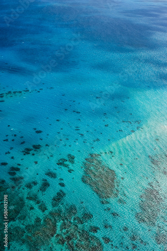 An aerial view of the coral reefs, white sand bars and cays, and clear turquoise waters of the Great Barrier Reef — Coral Sea, Cairns; Far North Queensland, Australia