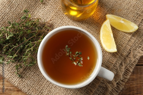 Aromatic herbal tea with thyme, honey and lemons on wooden table, top view