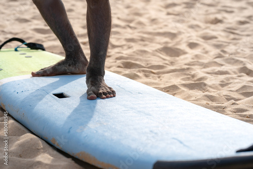 An example position of Asian professional feet on a surfboard in surfing board lesson study and training by the teacher.