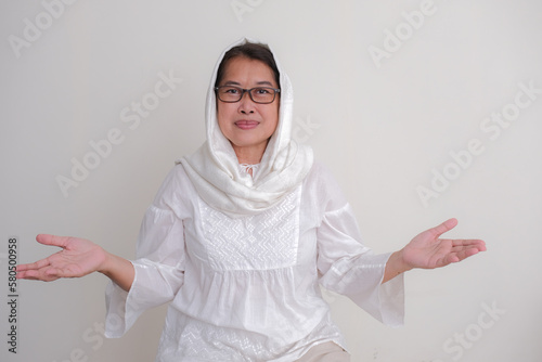 Indonesian moslem woman standing and smiling to politely greet photo