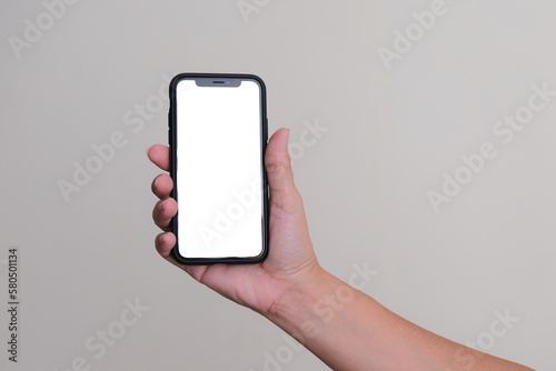 Hand holding a smartphone over white flat background photo